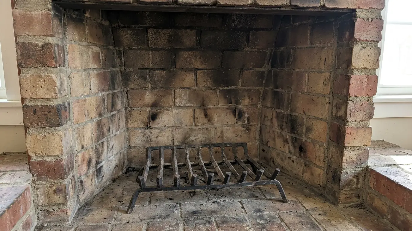 Before: a brick firebox with an empty firebox with a plain iron grate