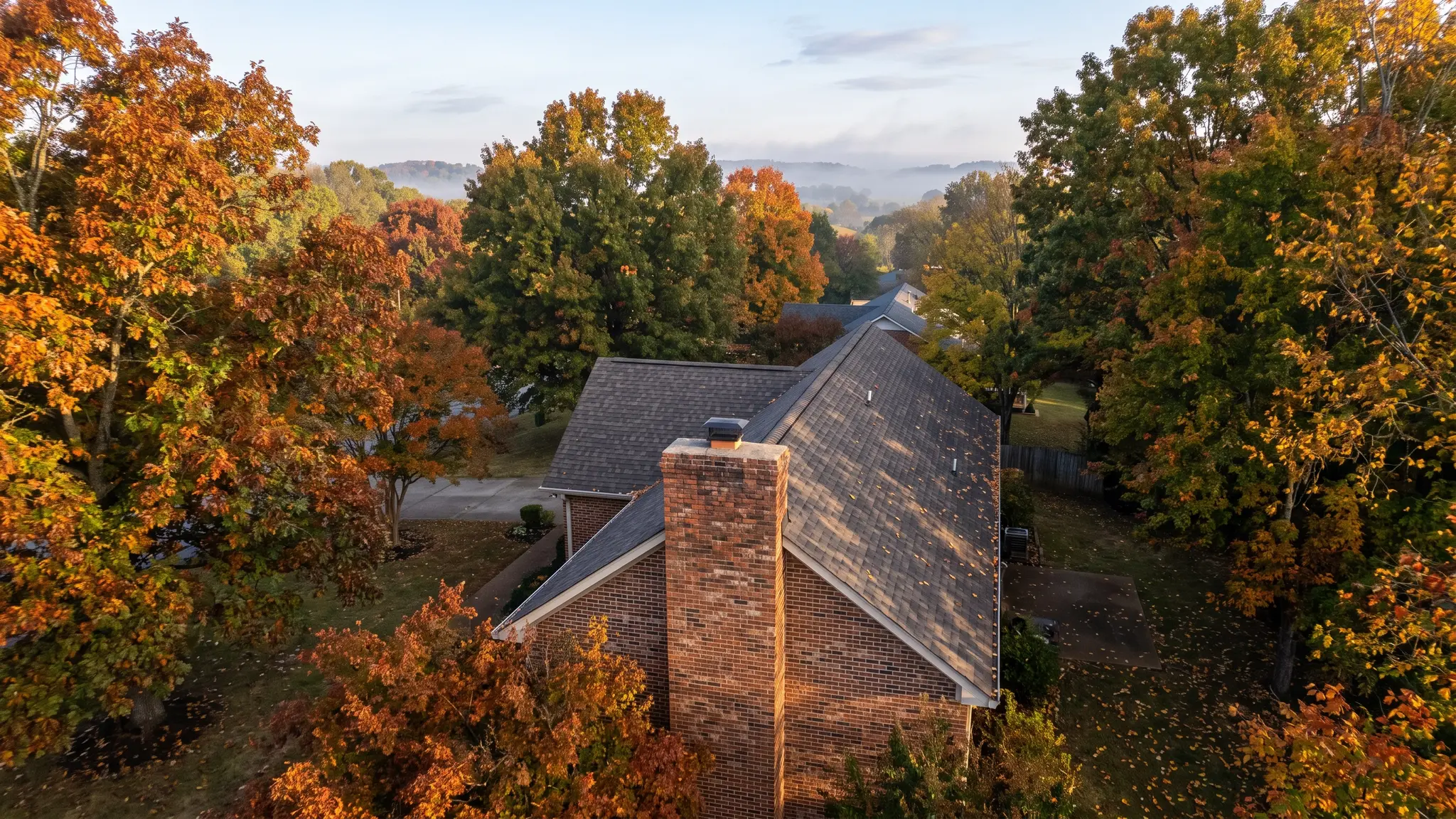 Chimney services | Music City Chimney An aerial view of a Tennessee neighborhood with brick homes and chimneys among trees in soft morning light